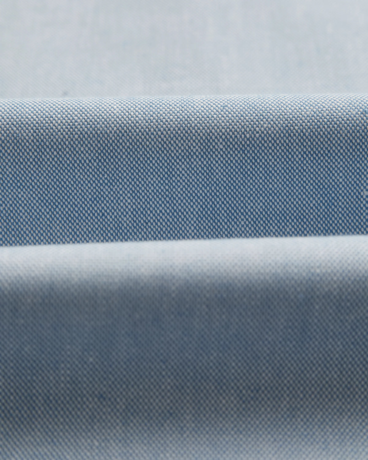 Gros plan sur le tissage texturé du coton bleu de la chemise Montebelo