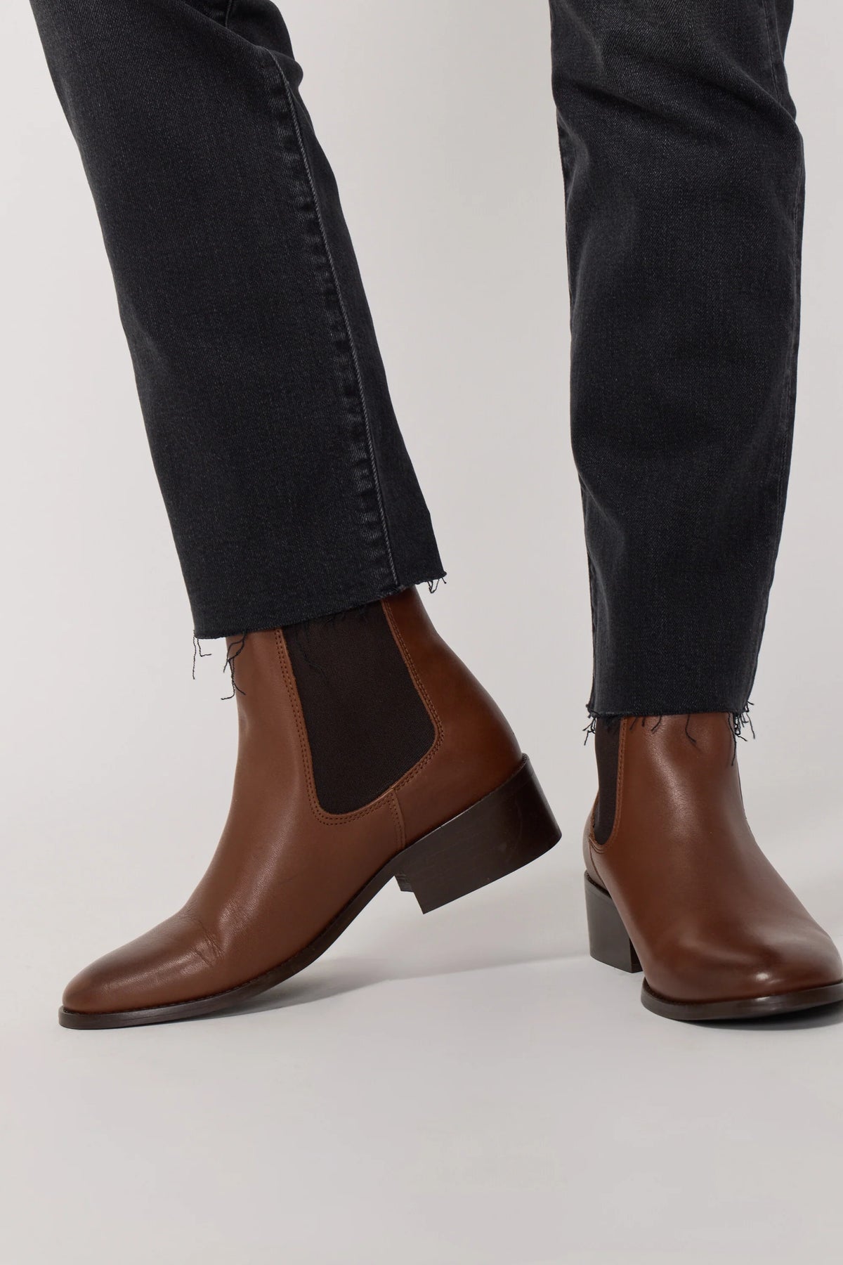 Détail du bas de jambe coupé franc du jean Cara avec bottines
