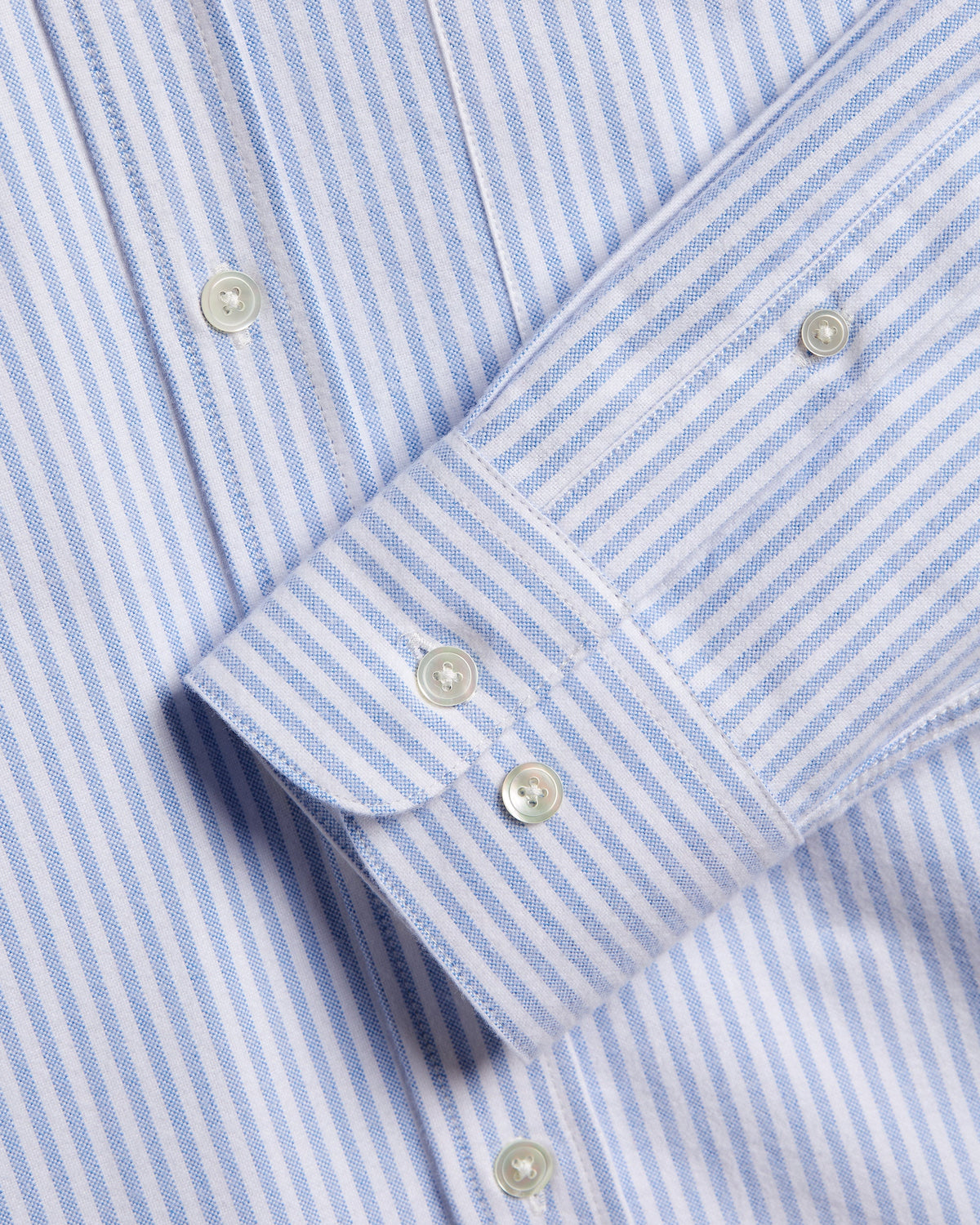 Poignet boutonné et boutons en nacre chemise rayée bleue