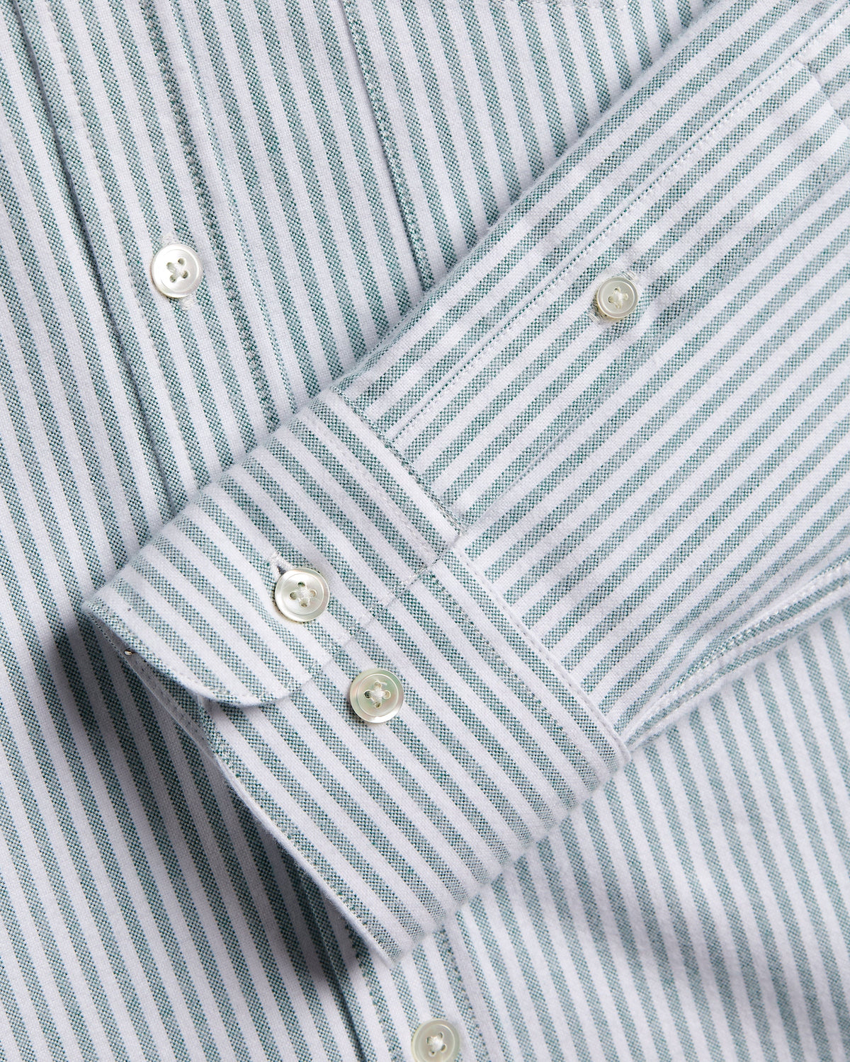 Poignet boutonné et boutons en nacre chemise rayée verte